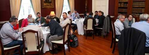 Three round tables with people chatting within the tables.